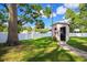 Large grassy backyard with a shed on a brick path, secured by a white fence at 2305 S Magnolia Ave, Sanford, FL 32771