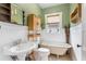 Charming bathroom with a clawfoot tub, vintage vanity, and lovely natural light at 2305 S Magnolia Ave, Sanford, FL 32771