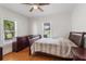 Comfortable bedroom with hardwood floors, dresser and natural light from windows at 2305 S Magnolia Ave, Sanford, FL 32771