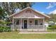 Charming pink single-story home featuring a covered porch with a swing and decorative elements at 2305 S Magnolia Ave, Sanford, FL 32771