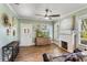 Cozy living room with light green walls, wood floors, a fireplace, and natural light at 2305 S Magnolia Ave, Sanford, FL 32771