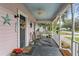 Inviting covered porch with seating, plants, ceiling fan and welcome mat at 2305 S Magnolia Ave, Sanford, FL 32771