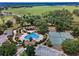 Aerial view featuring community pool, tennis courts, green spaces, clubhouse, and lush landscaping at 23533 Valderama Ln, Sorrento, FL 32776