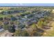 Aerial view of a residential neighborhood that is near a golf course, homes, and many trees at 23533 Valderama Ln, Sorrento, FL 32776