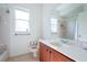 Simple bathroom featuring a single vanity, toilet, and a shower/tub combo with white tiles at 23533 Valderama Ln, Sorrento, FL 32776