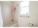 Cozy bathroom features a shower-tub combo with a neutral color scheme and a window that provides ample natural light at 23533 Valderama Ln, Sorrento, FL 32776