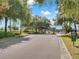 Gated community entrance featuring mature trees and well-maintained landscaping at 23533 Valderama Ln, Sorrento, FL 32776