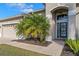 Inviting front entry featuring manicured landscaping, a brick pathway, and a stylish front door at 23533 Valderama Ln, Sorrento, FL 32776
