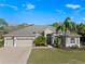 Charming home featuring a lush green lawn, mature landscaping, and a three-car garage at 23533 Valderama Ln, Sorrento, FL 32776