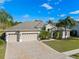 Beautiful home with a large driveway, lush lawn, mature landscaping, and a convenient three-car garage at 23533 Valderama Ln, Sorrento, FL 32776