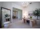 Bright home office featuring a modern chandelier, desk, and stylish decor, bathed in natural light at 23533 Valderama Ln, Sorrento, FL 32776