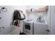 Functional laundry room with modern washer and dryer units, shelving, and a utility sink at 23533 Valderama Ln, Sorrento, FL 32776