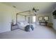 Bright and spacious main bedroom featuring a stylish canopy bed frame, neutral colors, and a ceiling fan at 23533 Valderama Ln, Sorrento, FL 32776