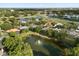 Aerial view of community homes surrounding a pond with a fountain and a nearby golf course at 240 Promenade Cir, Lake Mary, FL 32746