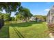 The expansive backyard features lush green grass, mature trees, a pond, and a charming playground area at 240 Promenade Cir, Lake Mary, FL 32746