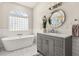 Serene bathroom with a freestanding tub, vessel sink, and glass block window at 240 Promenade Cir, Lake Mary, FL 32746