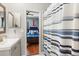 Bright bathroom offering a view to the attached bedroom and a blue/gray striped shower curtain at 240 Promenade Cir, Lake Mary, FL 32746