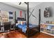 Stylized bedroom with a large bed frame, hardwood floors, study desk and bookshelf with decor at 240 Promenade Cir, Lake Mary, FL 32746