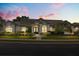 Charming stucco home with well-maintained landscaping and tile roof during dusk at 240 Promenade Cir, Lake Mary, FL 32746