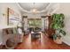 Cozy living room with hardwood floors, chandelier, and views of the lanai at 240 Promenade Cir, Lake Mary, FL 32746