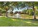 Scenic view of a serene pond with a fountain, framed by lush trees and a well-maintained lawn at 240 Promenade Cir, Lake Mary, FL 32746