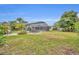 Spacious backyard with lush green grass, patio seating, and a view of the screened pool at 2510 Kiowa Trl, Fern Park, FL 32730