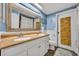 Stylish bathroom with a double sink vanity, decorative mirror, and modern fixtures at 2510 Kiowa Trl, Fern Park, FL 32730