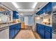 Bright kitchen with stainless steel appliances, blue cabinetry, and wood flooring at 2510 Kiowa Trl, Fern Park, FL 32730