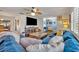Spacious living room with a comfortable blue sectional sofa, wood floors, and modern ceiling fan at 2510 Kiowa Trl, Fern Park, FL 32730