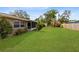 Large backyard with healthy green grass and partial view of the screened-in patio at 2618 Grassmere Ln, Orlando, FL 32808