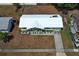 Aerial view of a single-story home featuring white roof, two chairs on the front porch and a driveway at 3212 Acoma Dr, Orlando, FL 32829