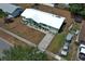 Aerial view of the light green house with a newly redone roof, long driveway, and mostly brown yard at 3212 Acoma Dr, Orlando, FL 32829