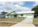 Beautiful one-story home featuring a green and white facade with an attached garage and xeriscaped front yard at 3212 Acoma Dr, Orlando, FL 32829