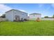 Wide backyard featuring green grass, playground set, patio with seating, and fencing around the perimeter at 4054 Silverstream Ter, Sanford, FL 32771