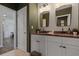 Bathroom with double vanity featuring granite countertop, stylish mirrors, and modern lighting at 4054 Silverstream Ter, Sanford, FL 32771