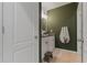 Stylish bathroom featuring an olive-green accent wall, white cabinets, and a granite countertop sink at 4054 Silverstream Ter, Sanford, FL 32771