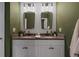 Bathroom with double vanity featuring granite countertop, stylish mirrors, and modern lighting at 4054 Silverstream Ter, Sanford, FL 32771