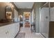 Spacious bathroom with double sinks, granite counters, tile floors, and a walk-in shower at 4054 Silverstream Ter, Sanford, FL 32771