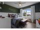 Charming bedroom with wood floors, ceiling fan, large window, and custom paint and trim details at 4054 Silverstream Ter, Sanford, FL 32771