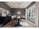 Dining room showcases dark walls, modern chandelier, and abundant sunlight through large windows at 4054 Silverstream Ter, Sanford, FL 32771