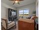 Bright living room featuring a modern entertainment center, cozy seating, and a picturesque window at 4054 Silverstream Ter, Sanford, FL 32771