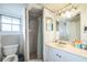 Modest bathroom featuring a vanity with double mirrors, a toilet, and a shower with a curtain at 419 Palm Ave, Eustis, FL 32726