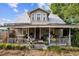 Charming two-story home with a metal roof and a covered porch, surrounded by landscaping at 419 Palm Ave, Eustis, FL 32726