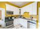 Cozy kitchen features white cabinets, stainless steel appliances, and a checkerboard backsplash at 419 Palm Ave, Eustis, FL 32726
