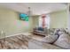 Cozy living room with wood-look floors, comfortable sofas, and natural light from the window at 4201 Chantelle Rd, Orlando, FL 32808
