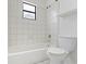 Clean bathroom features a tiled tub-shower, toilet, small window, and a shelf for added storage at 445 Cottonwood Dr, Altamonte Springs, FL 32714