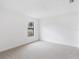 A bright bedroom with neutral carpet, white walls, window, and baseboard trim at 445 Cottonwood Dr, Altamonte Springs, FL 32714