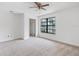 Bright bedroom featuring neutral carpet, ceiling fan, and a large window with neighborhood views at 445 Cottonwood Dr, Altamonte Springs, FL 32714