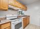 View of the kitchen featuring wood cabinets, marble countertops, white appliances, and a white stove at 445 Cottonwood Dr, Altamonte Springs, FL 32714
