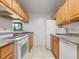 Functional kitchen featuring ample counter space, wooden cabinetry, and modern white appliances at 445 Cottonwood Dr, Altamonte Springs, FL 32714